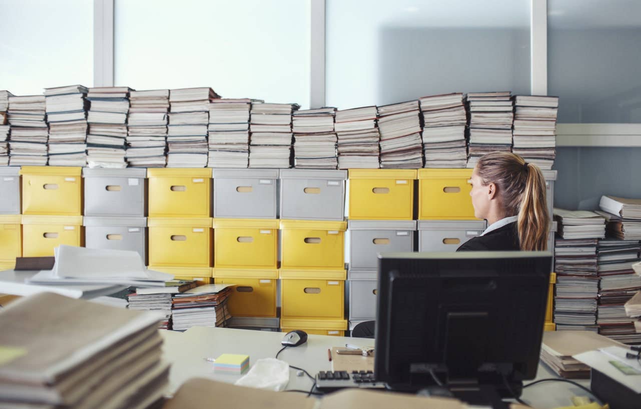 person looking at archive boxes and documents